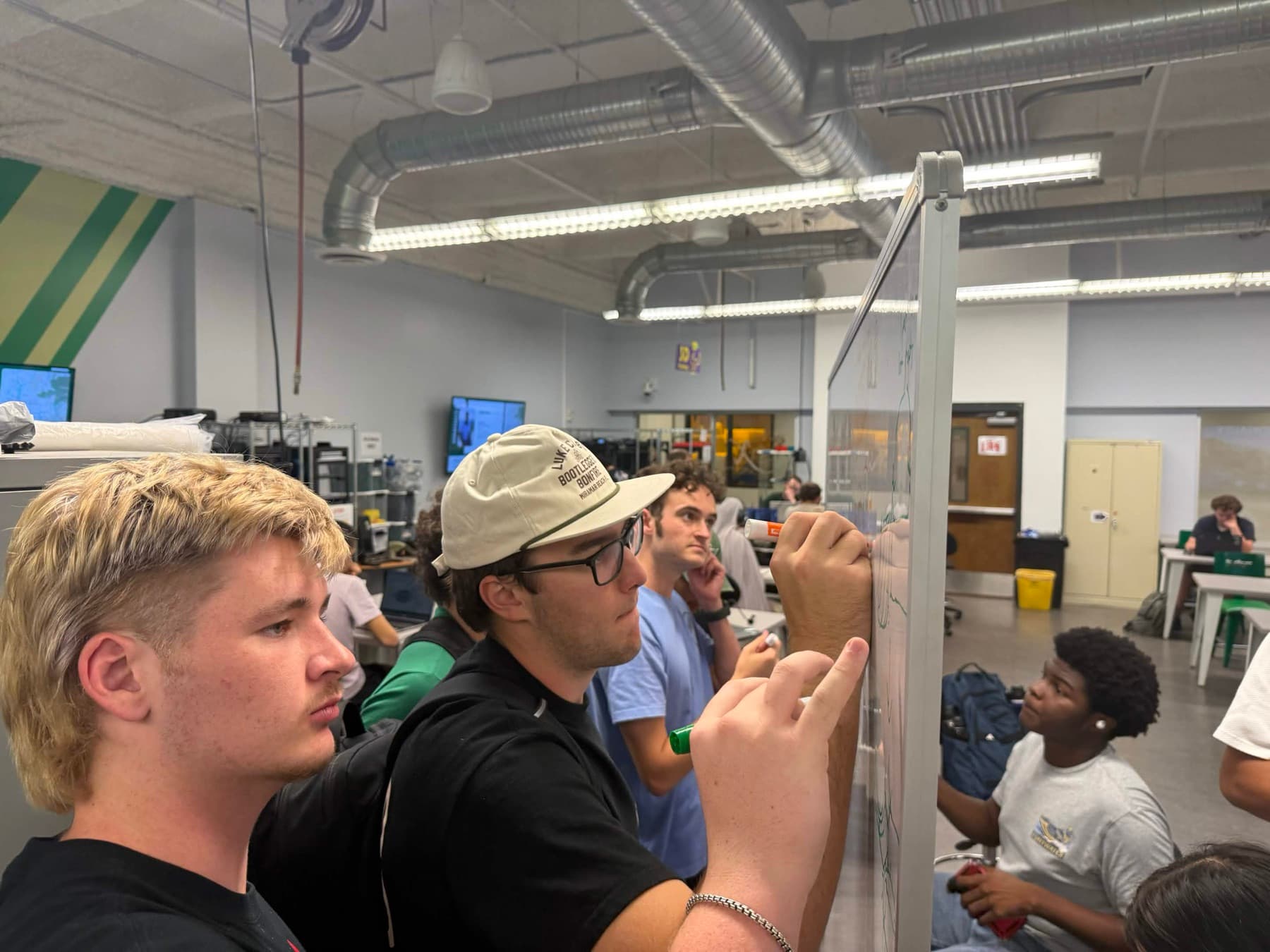 Members sketching rover designs on a whiteboard during a design session